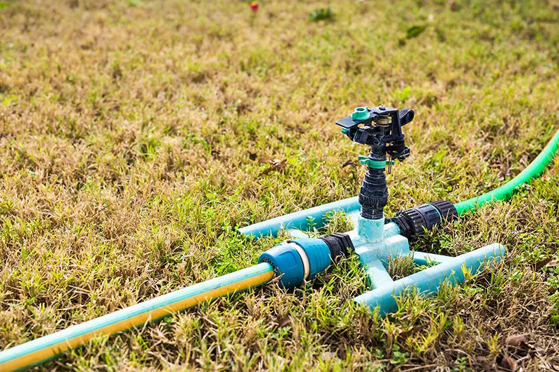 sprinkler head spraying water green grass